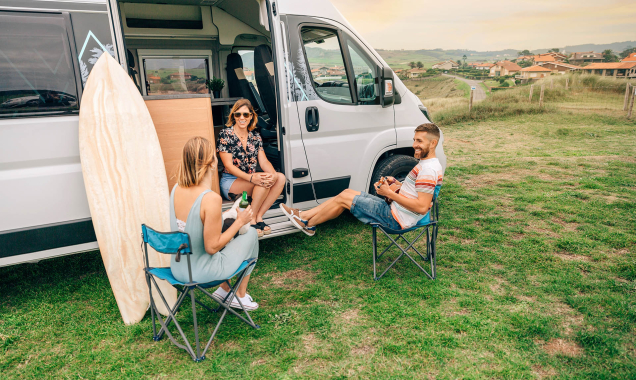 friends relaxing outside their camper 