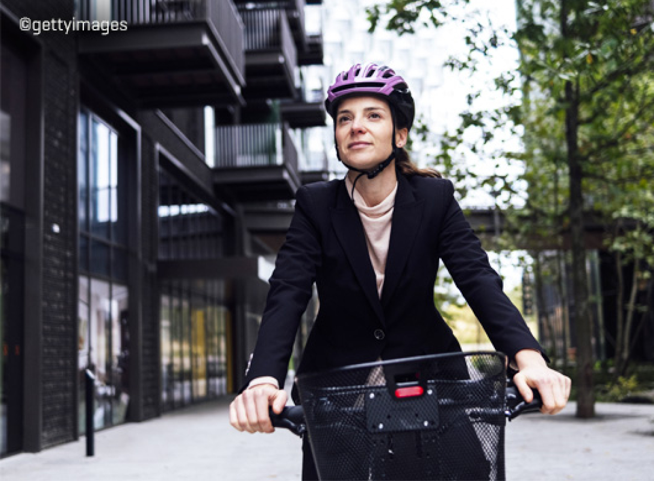 Vrouw op fiets met roze helm